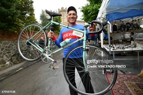 a-man-shows-his-vintage-bianchi-italian-bike-at-the-bicycle-parts-market-of-the-eroica-56205619.jpg